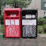 Altkleider-Sammelcontainer mit hinweisenden Schildern, um textile Abfälle und Recyclinganstrengungen zu fördern.