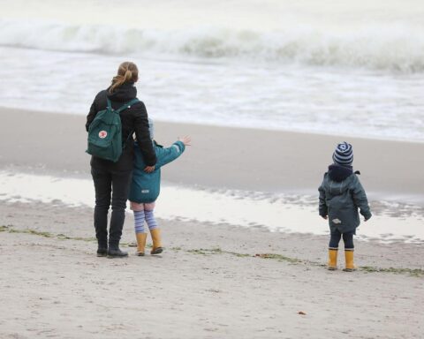 Strandbild mit Frauen, die zusammenarbeiten und sich gegenseitig unterstützen, symbolisiert Gleichberechtigung im Mutterschutz.