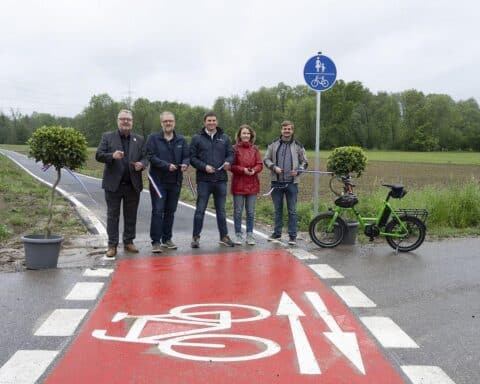 Eröffnung des neuen Radwegs: Bürgermeister und Projektbeteiligte beim feierlichen Banddurchschnitt.
