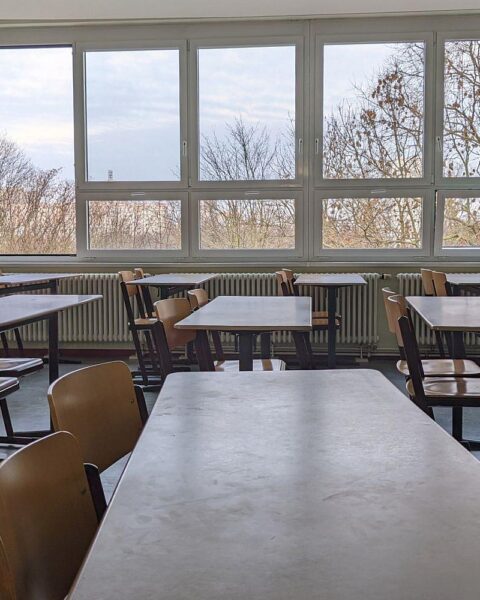 Schulklasse mit Schülern und Lehrern, die innovative Lernmethoden erproben und Auszeichnungen feiern.