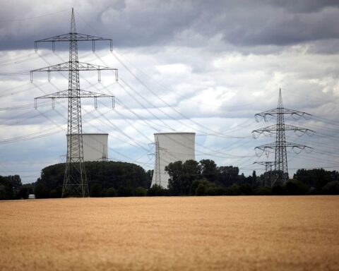 Ein Atomkraftwerk im Hintergrund, während Experten über erneuerbare Energien und Klimapolitik diskutieren.