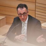 Cem Özdemir wird als Ministerpräsident vorgestellt, umgeben von symbolischen Elementen der Politik.