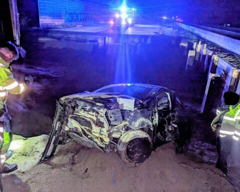 Verzerrtes Auto nach Unfall an Baustelle, schwer verletzter Fahrer, Polizei vor Ort.