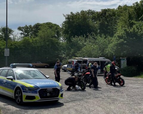 Polizisten kontrollieren Zweiräder, darunter Motorräder und E-Scooter, an einer Landstraße.