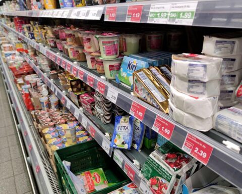Käse und Milchprodukte in einem Supermarktregal, Preissteigerungen deutlich visualisiert.