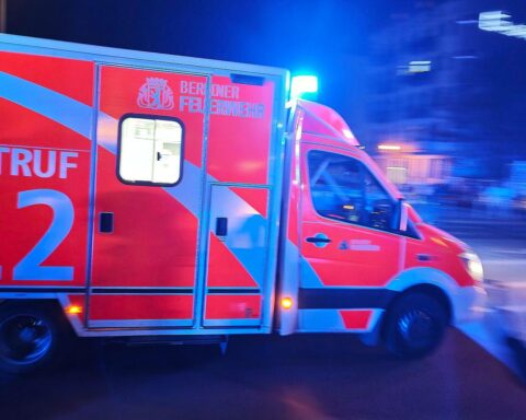 Rettungswagen mit Blaulicht, Unfallstelle, Radfahrer, Polizei, Verletzter, Kreuzung in Berlin.