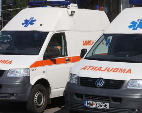 Rettungswagen vor Hochhaus, Einsatzkräfte helfen verletzten Personen nach Drohnenabsturz in Rumänien.