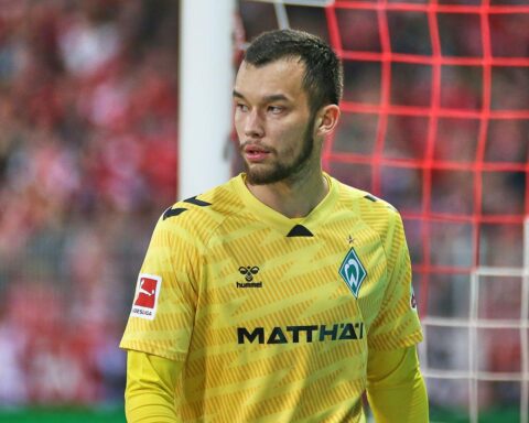 Mio Backhaus in SC Freiburg-Trikot, jubelnd in einem Stadion, Symbol für Neuanfang und Hoffnung.
