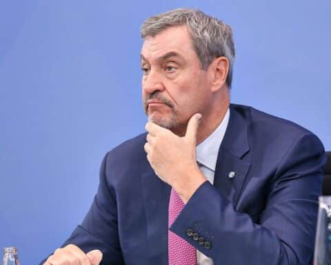 Markus Söder spricht leidenschaftlich, umgeben von bayerischen Symbolen und politischen Themen.