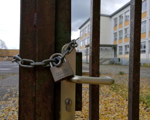 Abgeschlossenes Schultor symbolisiert die fortdauernde Schulsozialarbeit im Saarland für junge Menschen.