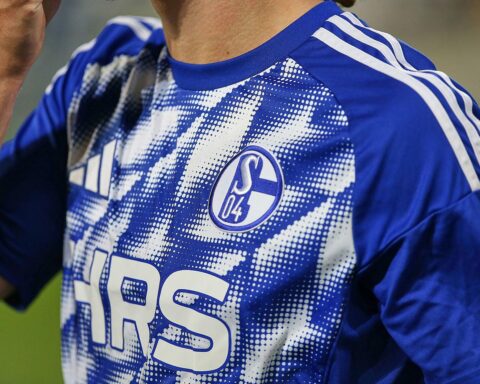 Schalke-Spieler feiern Aufstieg im Ratssaal, Oberbürgermeisterin überreicht Meisterschale, emotionale Atmosphäre.