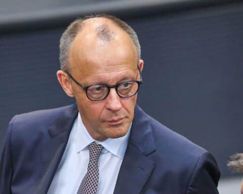 Friedrich Merz steht kritisch im Fokus, umgeben von Symbolen für Pflege und Inklusion.