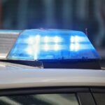 Zwei Polizeibeamte untersuchen Unfallstelle nach Auseinandersetzung zwischen Personengruppen in Neunkirchen.