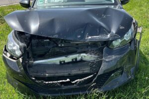 Unfall an Kreuzung: zwei beschädigte Autos, verletzte Personen, Polizei vor Ort.