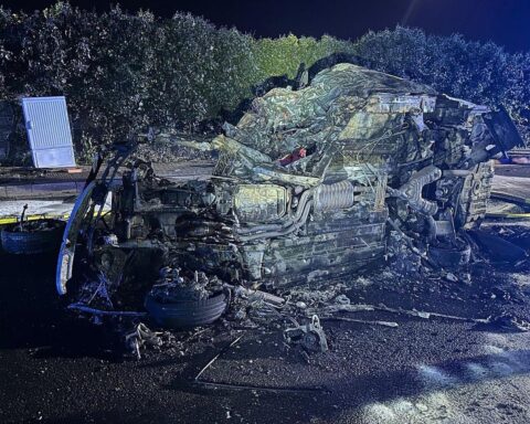 Schwerer Verkehrsunfall mit brennendem Auto, Feuerwehr im Einsatz, Verletzte werden versorgt.