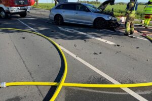 Zwei zerstörte Autos, Feuerwehr und Rettungskräfte am Unfallort, Einsatz von Rettungshubschraubern.