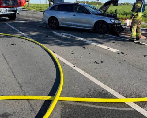Zwei zerstörte Autos, Feuerwehr und Rettungskräfte am Unfallort, Einsatz von Rettungshubschraubern.