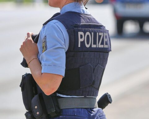 Ein Polizeiwagen am Grenzübergang mit festgenommenem Mann in Handschellen.
