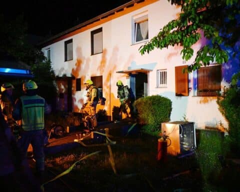 Feuerwehr im Einsatz, Rauch und Spülmaschine brennt in Reihenhaus. Rettungsdienst betreut Bewohner.