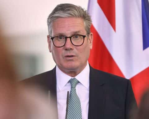Keir Starmer spricht, umgeben von Medien, während er Druck und Verantwortung anerkennt.