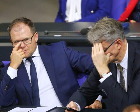 Zwei Bundesminister diskutieren über Infrastruktur und Umweltschutz, symbolisieren politischen Konflikt.