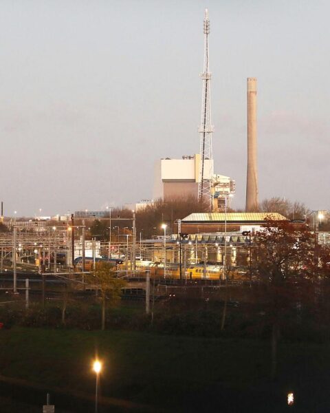Windräder und Kraftwerke symbolisieren die Verbindung zwischen erneuerbarer Energie und Stromversorgungssicherheit.