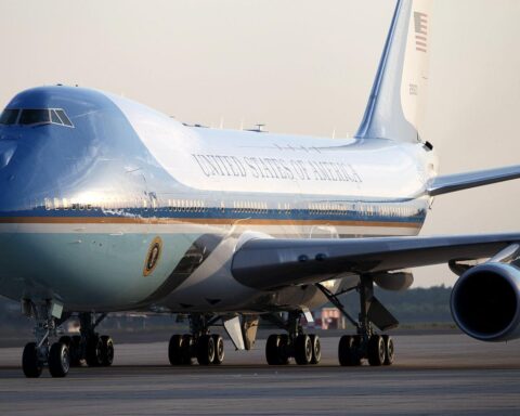 US-Präsident Trump bei Staatsbesuch in Peking, umgeben von Flaggen und chinesischen Offiziellen.
