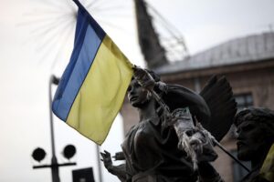 Ukrainische Flagge vor einem Hintergrund von militärischen Konflikten und Drohnenangriffen in Russland.