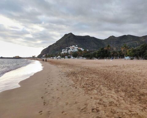 Strand auf Teneriffa, entspannte Urlauber trotz Unsicherheiten durch den Iran-Konflikt und steigende Reisekosten.