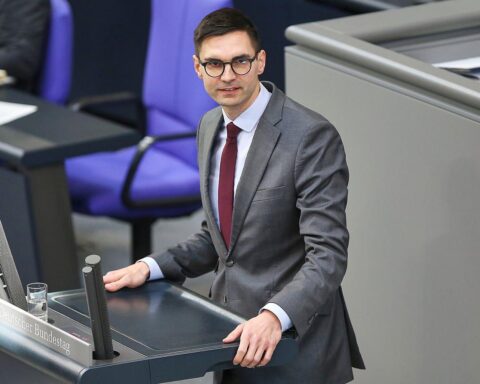 Sepp Müller diskutiert Renteneintrittsalter, strebt Erhöhung auf 70 Jahre an, Bild im Hintergrund.