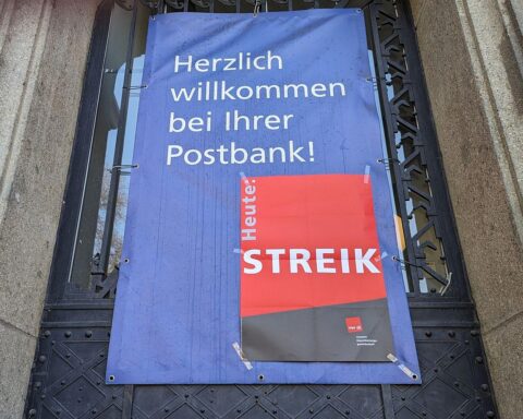 Streik-Hinweis an Postbank-Filiale zeigt Protest für höhere Gehälter und bessere Arbeitsbedingungen.