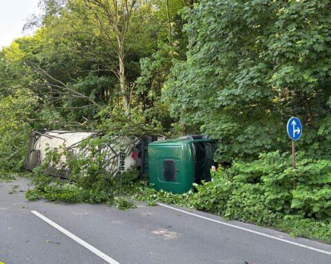 Unfallort mit umgekipptem Gefahrgut-LKW, Feuerwehr im Einsatz, gesperrte Straße und Rettungsmaßnahmen.