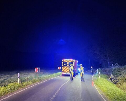Feuerwehr leuchtet Unfallstelle aus, Quad im Graben, Rettungsdienst transportiert Verletzten.