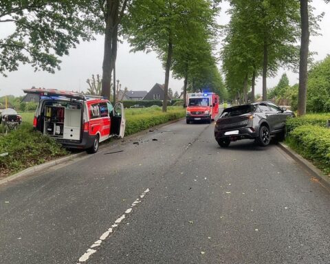 Notarzteinsatzfahrzeug und PKW nach Unfall, beide Fahrzeuge stark beschädigt, Einsatzkräfte vor Ort.