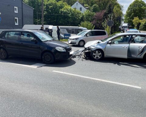 Zwei beschädigte Autos nach Unfall, Polizei vor Ort, verletzte Personen werden behandelt.