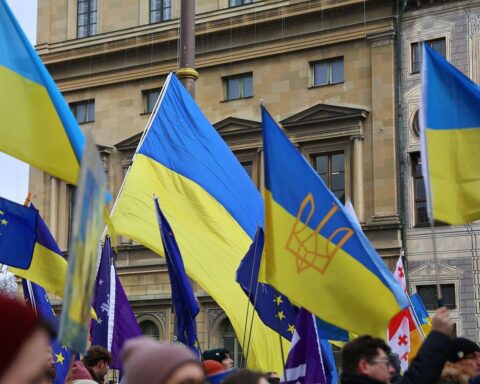Pro-Ukraine-Demo mit demonstrierenden Menschen, Schildern und Flaggen für Frieden und Unterstützung.