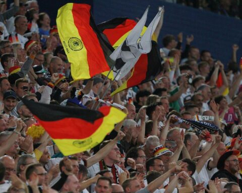 Eine begeisterte Fangemeinde in DFB-Trikots, feiernde Atmosphäre und Unterstützung für die Nationalmannschaft.