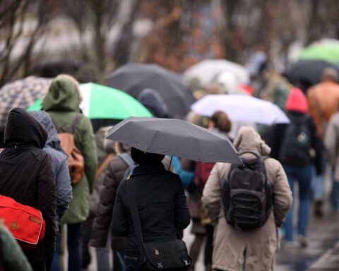 Trübes Wetter mit Regen, Menschen unter Regenschirmen in Mecklenburg-Vorpommern.