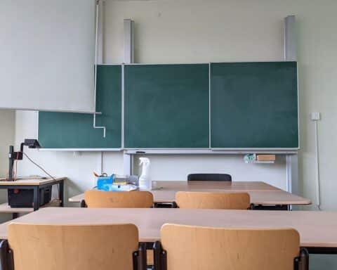Klassenraum mit Tafel und Stühlen, symbolisiert Bildung und die Diskussion über Beamte in Deutschland.