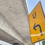 Umleitungsschild an einer gesperrten Straße wegen Straßeneinbruch und Wasserleitungsdefekt.