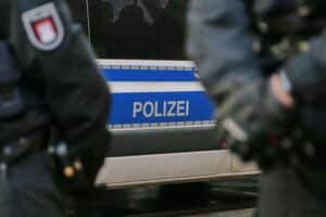 Polizisten überwachen Arbeitsbedingungen in der Logistik, Verdeutlichung von Schwarzarbeit und Mindestlohnverstößen.
