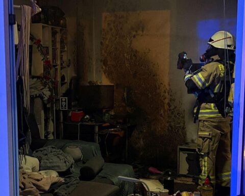 Ein Feuerwehrmann löscht Rauch aus einer Wohnung nach einem Brand durch Fahrradakku.