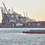 Industrieanlagen mit betroffenen Arbeitern und einem Symbol für Emissionshandel und Klimapolitik.