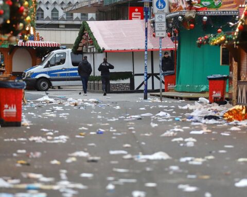 Tatort nach Weihnachtsmarkt-Anschlag: Polizei, Rettungsdienste, verwüstete Menschenmenge, emotionale Trauer und Aufregung.