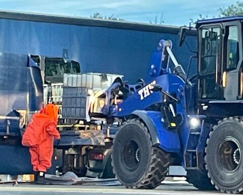 Einsatzkräfte bergen IBC-Container auf Rastplatz, Gefahrstoff unter Kontrolle, Wolken ziehen auf.