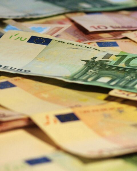 Euroscheine, symbolisierend steigende Zinskosten, Staatsverschuldung und wirtschaftliche Herausforderungen in der EU.