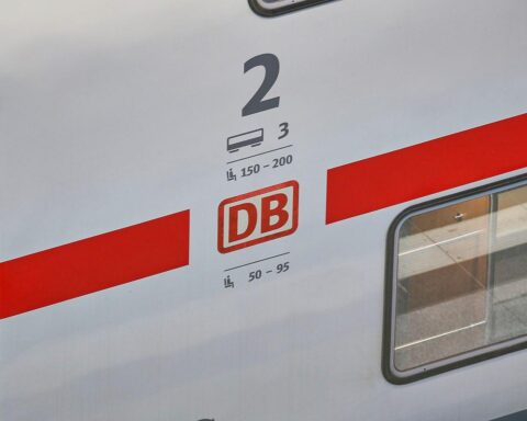 Pünktlicher ICE von Deutsche Bahn an Bahnhof, Grafik zur Pünktlichkeit in Hintergrunden.