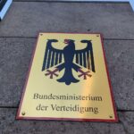 Verhandlungstisch mit Vertretern, Panzer-Modell im Hintergrund, Unsicherheit über Staatseinstieg in KNDS.