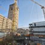 Stuttgart 21 Baustelle mit Bauarbeiten und Verzögerungshinweisen auf Plakat oder Banner.