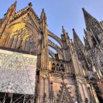 Kölner Dom mit Eintrittsschild: Symbol für nachhaltige Finanzierung und spirituelle Erhaltung.